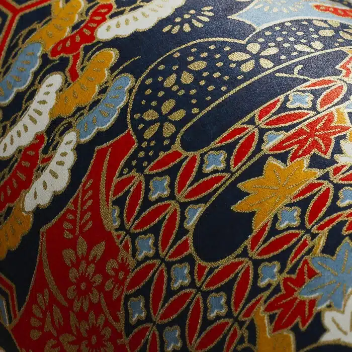Détail du motif de la boîte Sanuki en papier washi japonais, fleurs rouges, or, blanches et bleues avec nuages et vagues géométriques